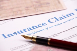 An insurance claim form with a pen on top showing that we handle Allstate insurance claims in Ohio